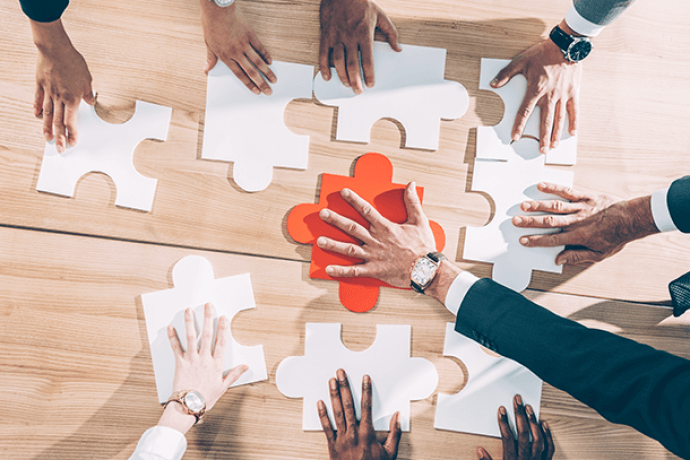 hands arranging big puzzle pieces on the floor