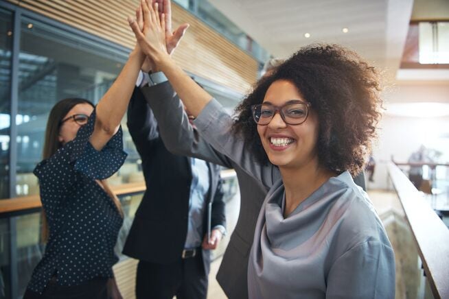 Smiling employees high five