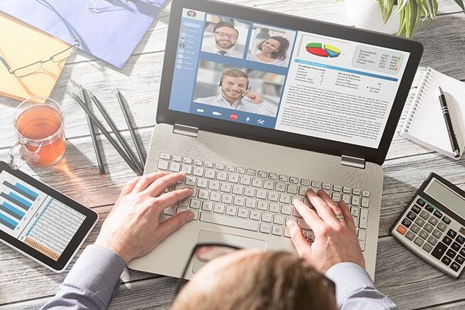 a person watching a video call / presentation on their laptop - view from above