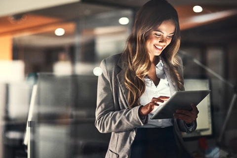 a woman smiling down at iPad